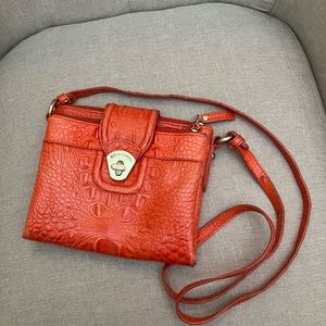 Brahmin orange crossbody with zippered compartments and  credit card spaces.